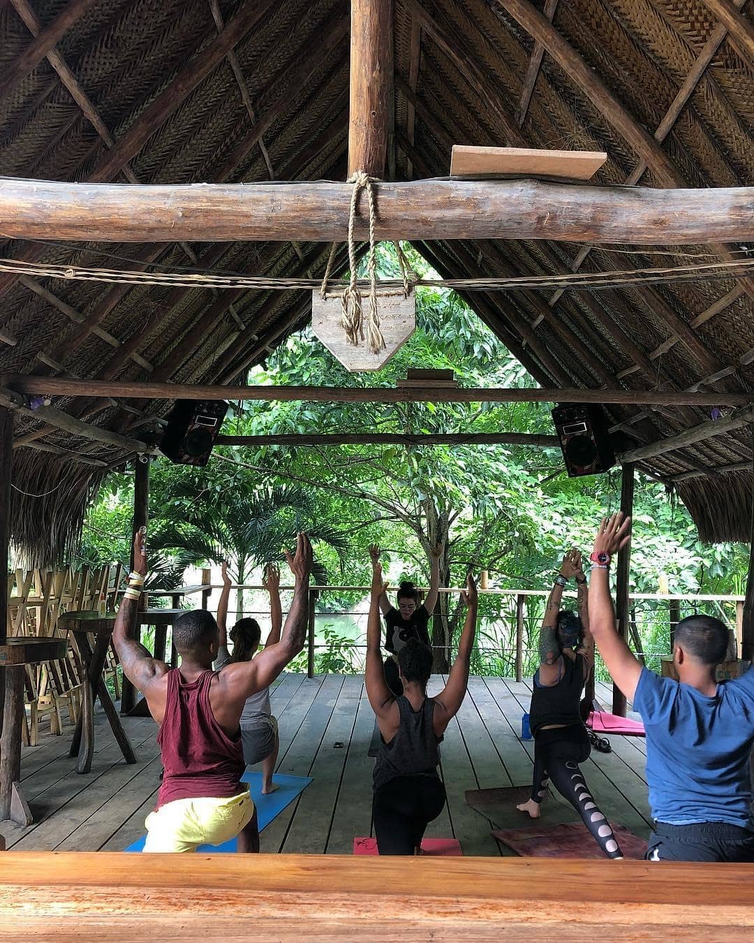 how to avoid overtourism, people doing yoga in a wooden shack
