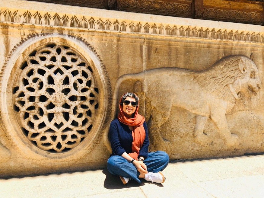 female hostel owners, girl sitting by wall with carved lion in Iran